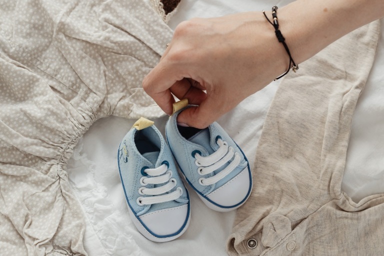 赤ちゃんの靴を持つ新米ママの手